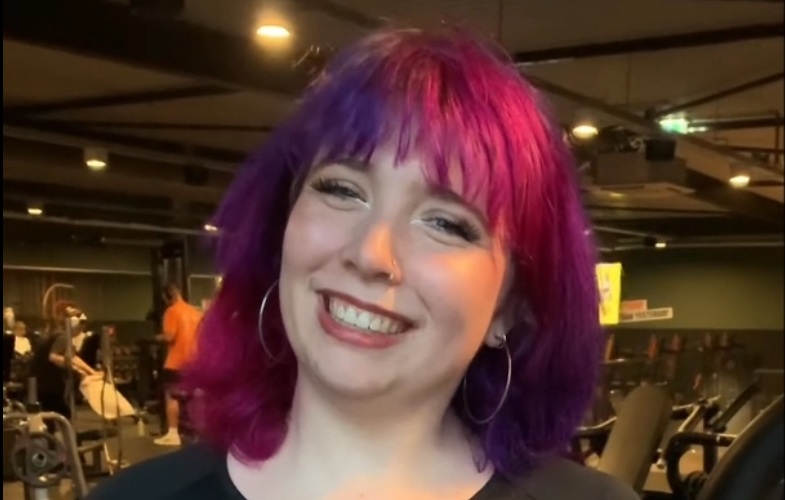 Foto van stagiaire Yvonne, die in de sportschool staat en naar de camera lacht.